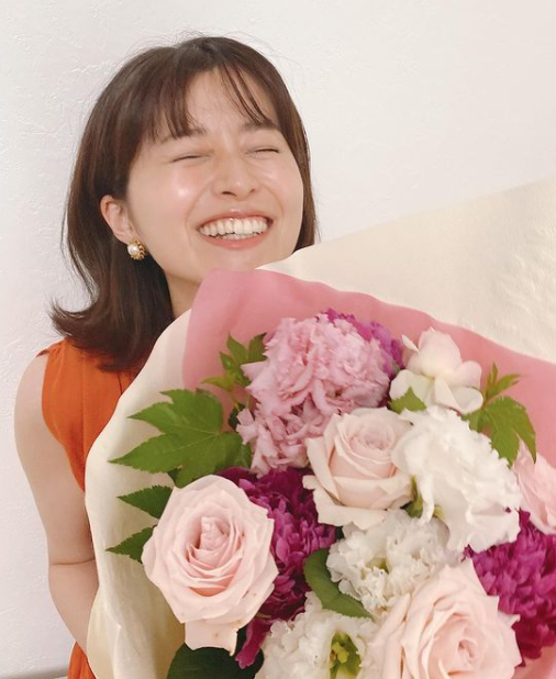 鈴木ちなみさんが花束を持って喜んでいる写真